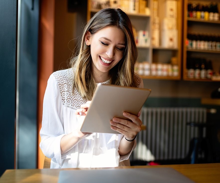 Smiling woman using a tablet to review her website design project, symbolizing creativity, digital success, and professional web design services by Dilasha Tech India Pvt Ltd.